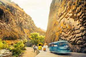 Motion people visit sightseeing popular travel destination in armenia - Basalt columns in Garni Gorge, know as Symphony of Stones. Geological formation of octagonal basalt columns. Motion blur photo