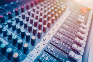 Closeup multi channel digital sounds mixer for voice recording. Sound engineer tools editor in studio or stage show instruments blue color tone photo