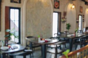 Interior portrait of a restaurant with a lot of tables and chairs. photo