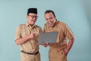 Two cheerful government worker men and holding a laptop discussing about their task. photo