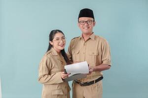 Government worker couple in khaki uniform holding a document report while smiling to the camera. photo