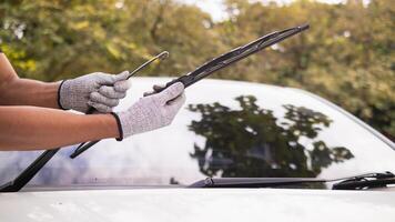 mechanic is checking car wiper blades to replace new wiper blades for car during the rainy season because when it rains it can be used at full efficiency. Checking and cleaning the car wiper blades photo
