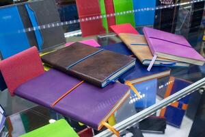 Multi-colored notepads on the counter of a stationery store photo