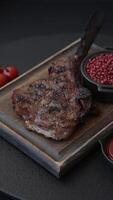 Grilled wagyu beef tomahawk steak with salt, spices and herbs on a dark concrete background video