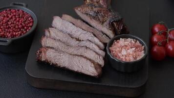 Grilled wagyu beef tomahawk steak with salt, spices and herbs on a dark concrete background video