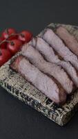 Grilled wagyu beef tomahawk steak with salt, spices and herbs on a dark concrete background video