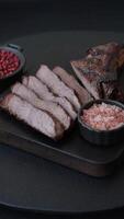 Grilled wagyu beef tomahawk steak with salt, spices and herbs on a dark concrete background video