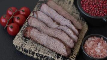 Grilled wagyu beef tomahawk steak with salt, spices and herbs on a dark concrete background video