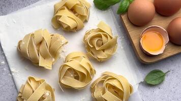 Chef arranging pasta nests on floured surface video
