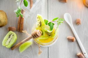 Homemade yogurt in a glass jar with honey, kiwi, nuts. photo