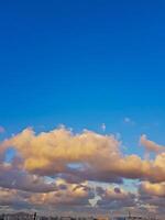 Wispy clouds drift across the upper half of the horizon, casting a soft, ethereal glow over the city photo