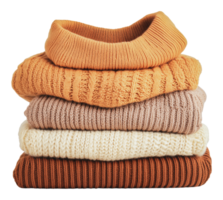 Cozy knit sweaters stacked neatly on a table png