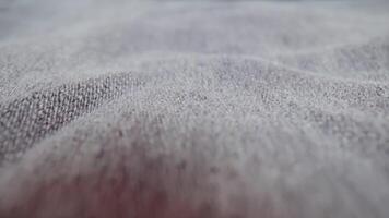 Dark denim pants fabric lying on table surface in studio video