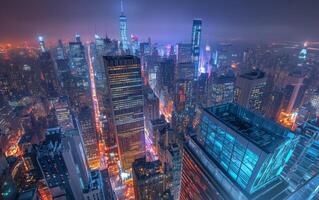 A rooftop view of a city at night, skyscrapers and busy streets far below, glowing lights photo