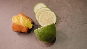 Fresh cupcake with custard and sliced lime lie on table video