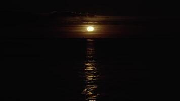 Lunar disk light reflects on water creating path in sea video