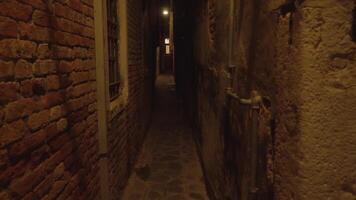 Dark narrow Venetian passageway with lamp illuminating way video