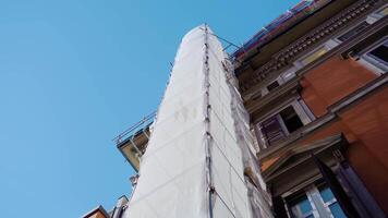 Old building under reconstruction with scaffolding fabric video