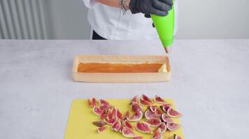 Person decorates biscuit with cream using piping bag video