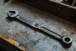 Adjustable wrench lying on workbench in workshop photo