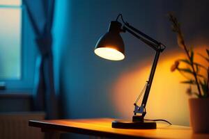 Modern desk lamp illuminating empty desk in room at night photo