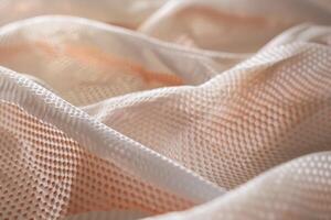 White and pink fabric with honeycomb pattern forming abstract shapes photo