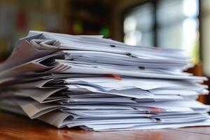 Stack of documents piling up on a desk representing overworked photo