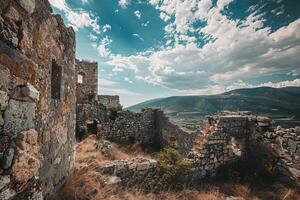 Ruins of ancient stone building standing on hill overlooking valley photo
