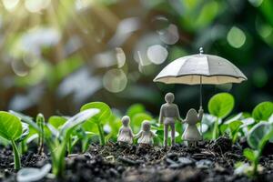Family of figurines standing under umbrella protecting them from rain in lush green environment photo
