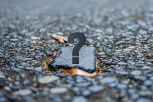 Question mark standing on stone path representing uncertainty photo