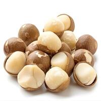Shelled and unshelled macadamia nuts piled on white background photo