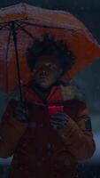 A young person holds an umbrella in a vibrant, snowy, and atmospheric urban setting video