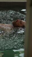 A man is floating effortlessly and calmly in serene, tranquil water, enjoying the moment video