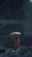 A solitary figure stands out in a snowy landscape while holding a bright orange umbrella video