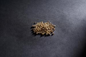 coriander seed isolated on dark background, spice concept, a Close-up background texture of dried coriander seeds photo