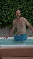 A Man Enjoying His Time Standing in a Refreshing Pool During a Relaxing Summer Setting video