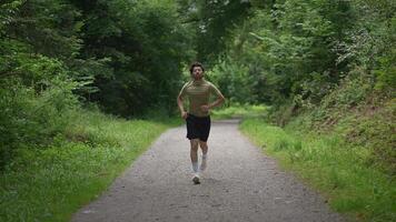 A Man is Enthusiastically Running on a Beautiful Scenic Trail Surrounded by Lush Nature video