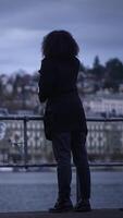 A figure stands looking over a vast cityscape at dusk, embodying serenity and reflection video