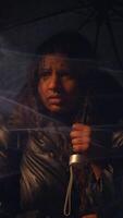 A moody urban scene showcases a person with an umbrella in a rainy, atmospheric setting video