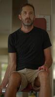 A Man Sitting with a Prosthetic Arm in a Stylish and Modern Setting That Conveys Strength video