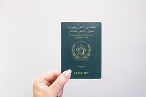 Passport Afghanistan Held Against Simple White Background. Astana, Kazakhstan, 26 october 2024 photo