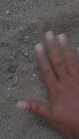 The captivating texture of dark sand interspersed with various pebbles can enhance visuals video