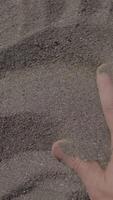 A CloseUp View of a Hand Interacting with the Soft Sand at a Beautiful Beach Location video