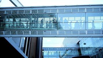 A modern pedestrian bridge elegantly designed, showcasing busy commuters crossing it at peak times video