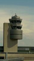 A modern airport control tower standing tall amid a beautiful, cloudy sky backdrop video