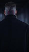 An enigmatic and mysterious figure dressed in dark attire stands alone, casting a profound shadow video