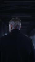 A mysterious figure is walking through a dimly lit corridor, surrounded by shadows and depth video