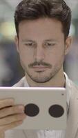 A Focused Man Concentrating While Using a Tablet in a Contemporary, Modern Environment video