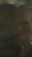A man gazes thoughtfully at his reflection in glass, evoking introspection and depth video