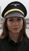 Confident female pilot in uniform and cap, displaying her dedication and skill in aviation video